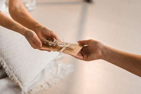 A woman in white clothes passes an envelope with a wish to another woman. The concept of the women's circle.の写真素材