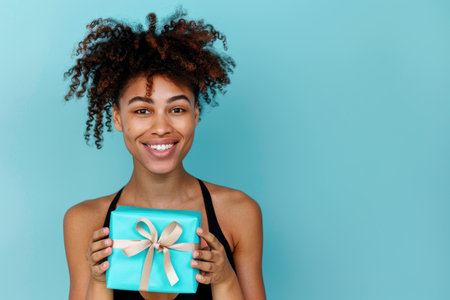 Happy birthday girl with a gift in her hands on a blue background.の素材