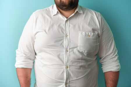 The body of a fat man in a white shirt on a blue background. An overweight man in a white shirt.の素材