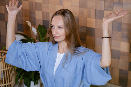 Yoga instructor in blue at fitness gym . The girl does qigong yoga. The exercises are based on the...