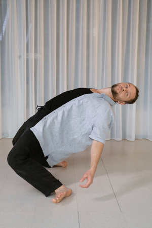 A man performs a randomized movement for yoga at a fitness gym.の写真素材