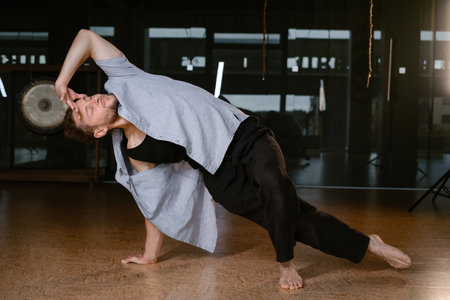 A man performs a randomized movement for yoga at a fitness gym.の写真素材