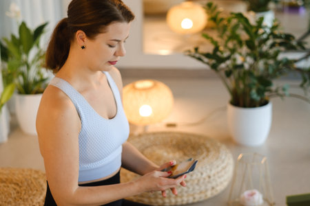 A sporty girl lays out Tarot cards indoors. Tarot cards in the hands of a fortune teller.