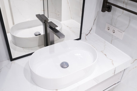 Chrome water faucet and white pedestal sink in bathroom . Stylish bathroom.の写真素材