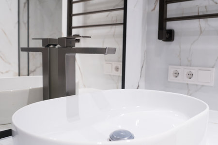 Chrome water faucet and white pedestal sink in bathroom . Stylish bathroom.の写真素材