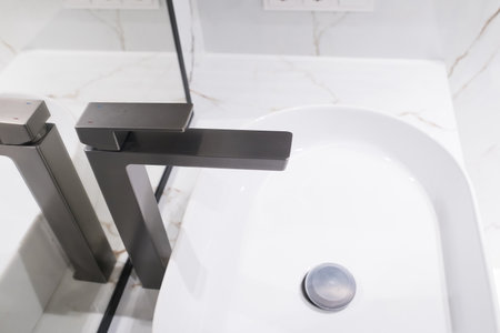 Stylish deluxe water faucet and white countertop sink in bathroom. Stylish bathroom.の写真素材