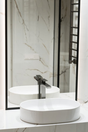 Stylish deluxe water faucet and white countertop sink in bathroom. Stylish bathroomの写真素材