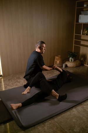Girl in Thai massage session from therapist in massage room . Traditional Asian stretching therapy.の写真素材