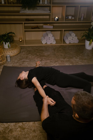 Girl in Thai massage session from therapist in massage room . Traditional Asian stretching therapy.の写真素材