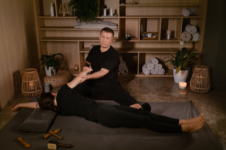 Girl in Thai massage session from therapist in massage room . Traditional Asian stretching therapy.の写真素材