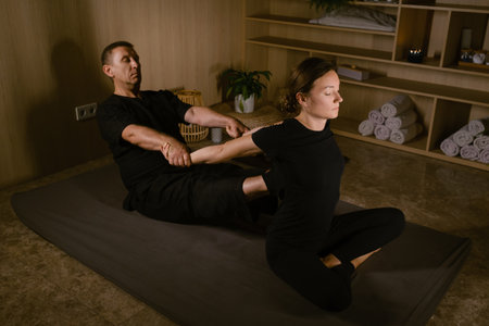 Male massage therapist performs back massage for pain treatment in spa. Thai massage with masseur in spa.の写真素材