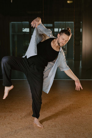 A man performs movements during a yoga class at a fitness gym.の写真素材