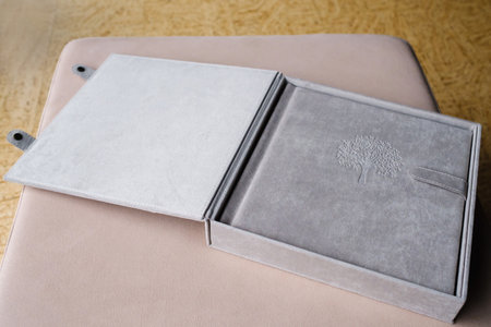 A photo book in a grey cloth cover lies on the box. the concept of creating books and albums from photographs. professional photographer and printing services.の写真素材