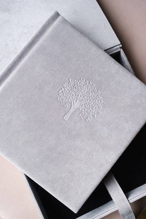 A photo book in a grey cloth cover lies on the box. the concept of creating books and albums from photographs. professional photographer and printing services.の写真素材