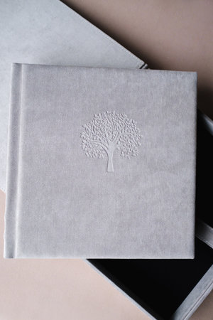 The photo book is grey in a soft cloth cover. the concept of creating books and albums from photographs. professional photographer and printing services.の写真素材