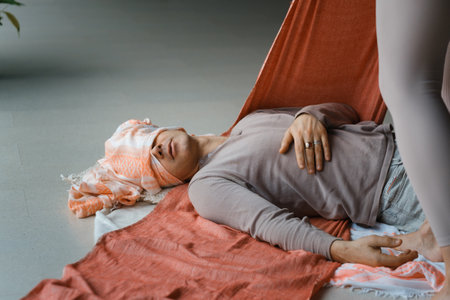 Relaxation and healing during a restorative yoga session with supportive props in a serene indoor environmentの写真素材