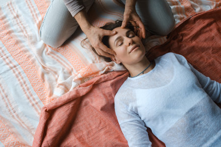 Relaxation and healing through gentle massage in a serene indoor setting during a wellness sessionの写真素材