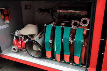 Training exercises are taking place at a fire station, showcasing the firefighting equipment in use, including hoses, valves, and control panels, reflecting teamwork and preparedness.の写真素材