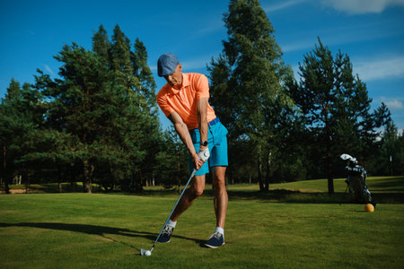 Golfer swings at a sunny course in summer, showcasing perfect form and technique while preparing for...
