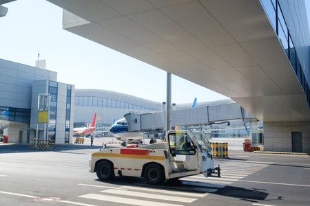 A ground support vehicle operates on the tarmac of a bustling airport, surrounded by parked planes....