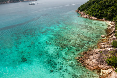 A beautiful rocky coastline meets clear turquoise waters in a tropical location on Redang Island in Malaysia.の写真素材
