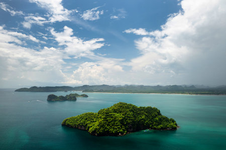 Scenic view of lush green islands and calm waters on a sunny day on the tropical island of Langkawi....