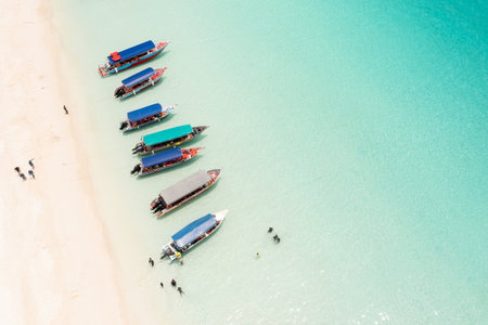 Colorful boats parked along a tropical beach, with tourists on Redang Island. Malaysia