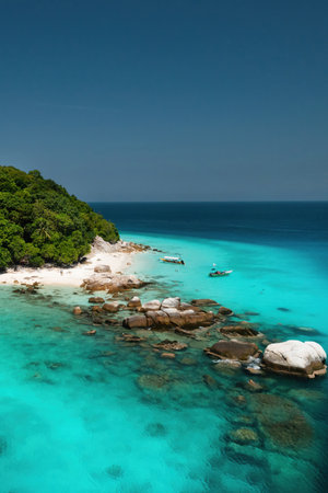 A bright beach with clear turquoise waters and lush greenery on a sunny day on the island of Lang Tengah in Malaysiaの写真素材