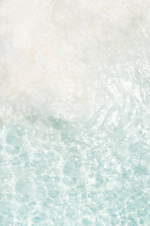 Beautiful sunlight shining on rocks in clear blue water at a tranquil beach location during the afternoon hours in a serene natural settingの写真素材