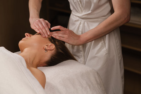 Relaxation and rejuvenation during a facial treatment at a serene spa, showcasing hands gently...