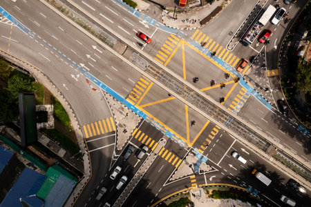 Top view of traffic moving through a busy intersection surrounded by buildings on a sunny city day. Kuala Lumpur. Malaysiaの写真素材