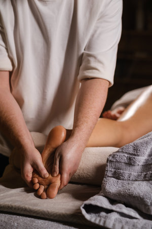 The expert foot massage technique performed by the master, performed in a calm spa environment, is aimed at relaxation and stress relief for the clientの写真素材