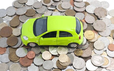 Green car on a pile of coinsの写真素材