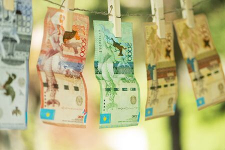 Money laundering concept. Kazakhstan tenge hanging on a rope. Pure money.の写真素材