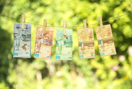 Money laundering concept. Kazakhstan tenge hanging on a rope. Pure money.の写真素材
