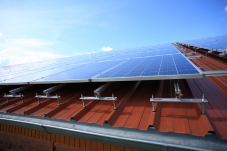 Solar panels placed on roof against blue skyの写真素材
