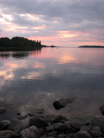 A lonely boat on the background of the forest lakeの写真素材