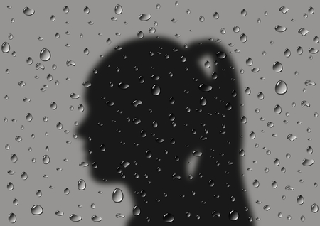 Raindrops on the window, silhouette of a girl, rainy weatherの写真素材