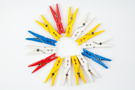 colored plastic clothespins spread out near one another on a white backgroundの写真素材
