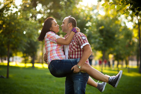 cheerful young couple relaxing in the park on the grass and in the cityの写真素材