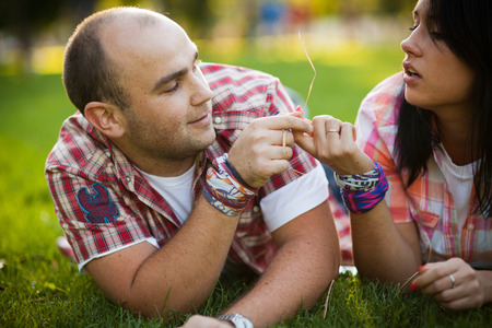 cheerful young couple relaxing in the park on the grass and in the cityの写真素材