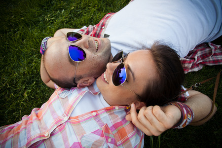 cheerful young couple relaxing in the park on the grass and in the cityの写真素材