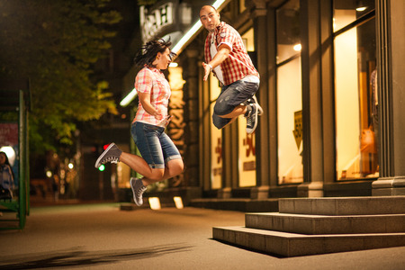 cheerful young couple relaxing in the park on the grass and in the cityの写真素材