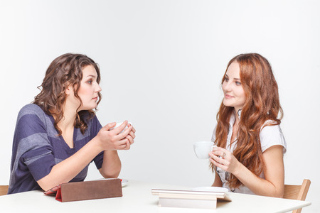 Girls at the table looking at a tabletの写真素材