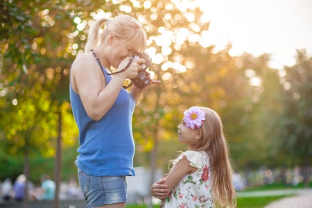 Woman photographing child in the park