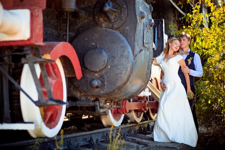 Portrait of happy wedding couple near the old steam locomotive summerの写真素材