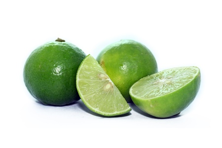 Limes with slices and leaves isolated on white background の写真素材