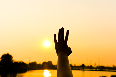 Silhouette of hand behind glass foreground