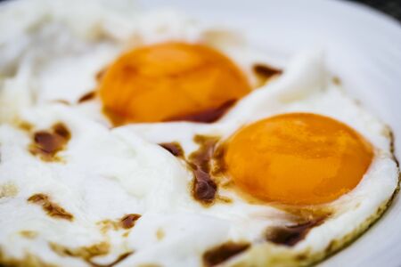 Organic Chicken Eggs Being Fried on Cast Iron Skilletの写真素材