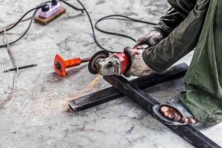 Technicians use grinding machines to cut steel pipes